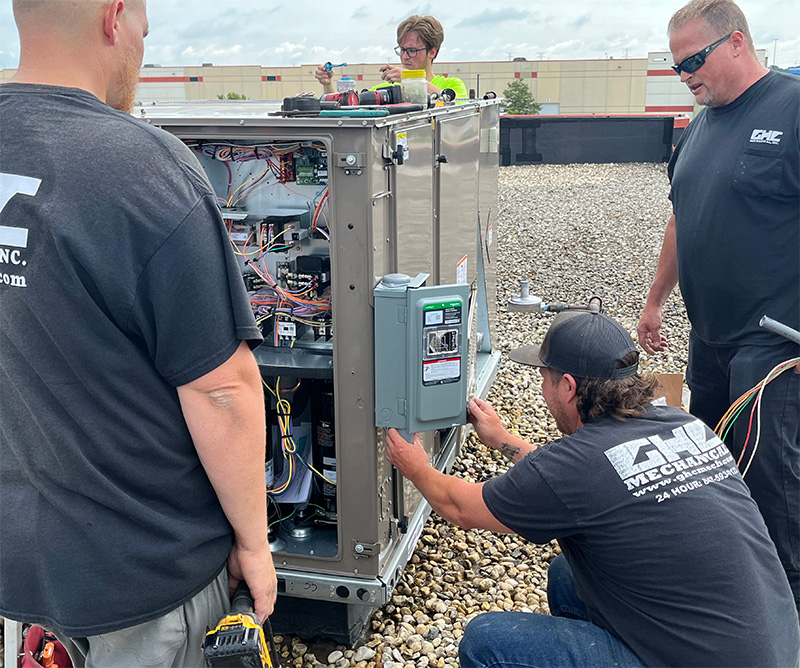 GHC Technicians Working on Outside HVAC Unit